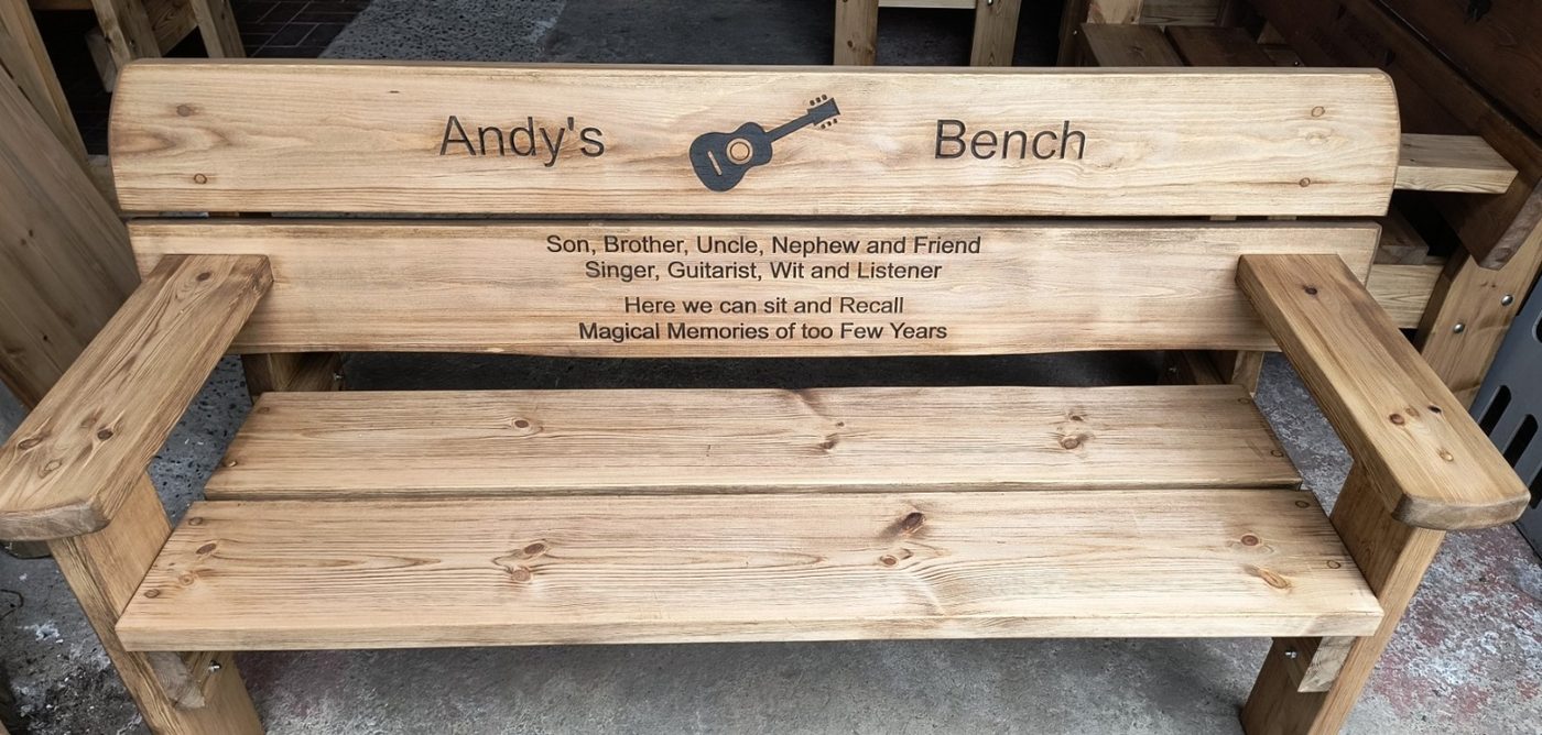 Dedication bench with a guitar carved into the backrest