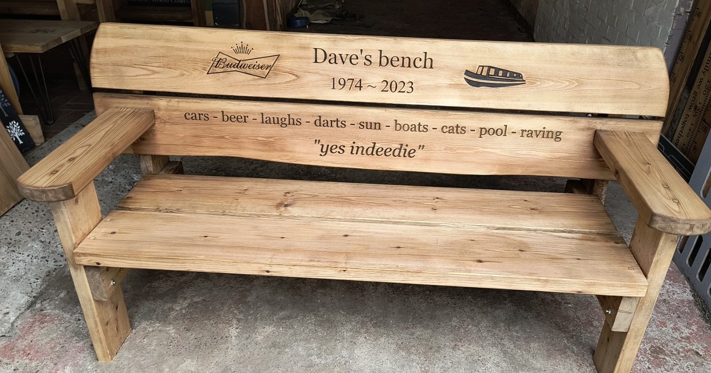 Dedication bench carved with a name, dates and a list of favourite things